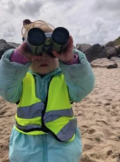 Nurery child looking through binoculars